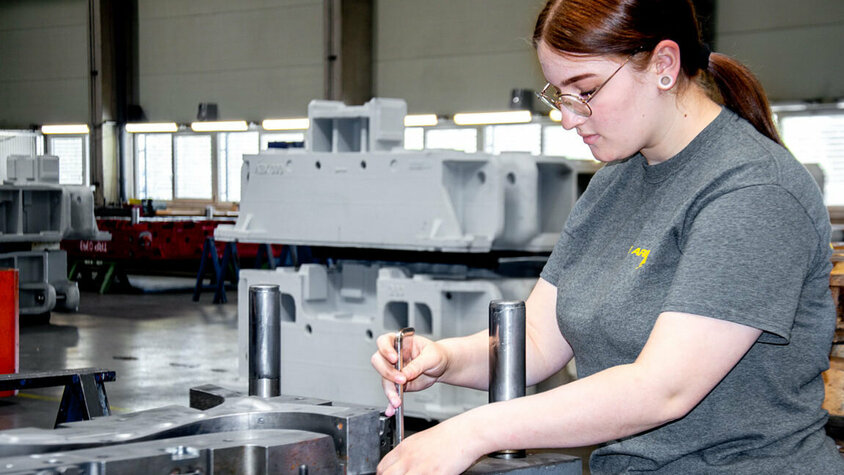 Eine junge Werkzeugbautechnikerin montiert in ihrer Lehre in Steyr bei weba Werkzeugbau Stanzwerkzeuge.