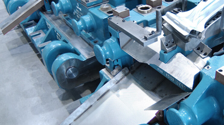 Ausschnitt eines blauen Umformwerkzeugs zur Produktion von B-Säulen aus hochfesten Blechen für Fahrzeuge.